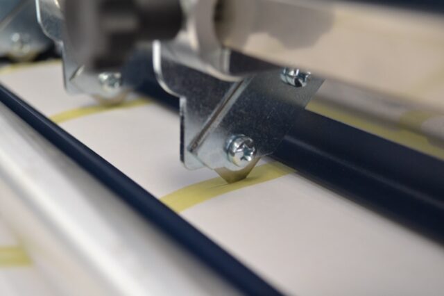 Slitter blade cutting liner. LT5C inline label rewinder and slitter for narrow label rolls